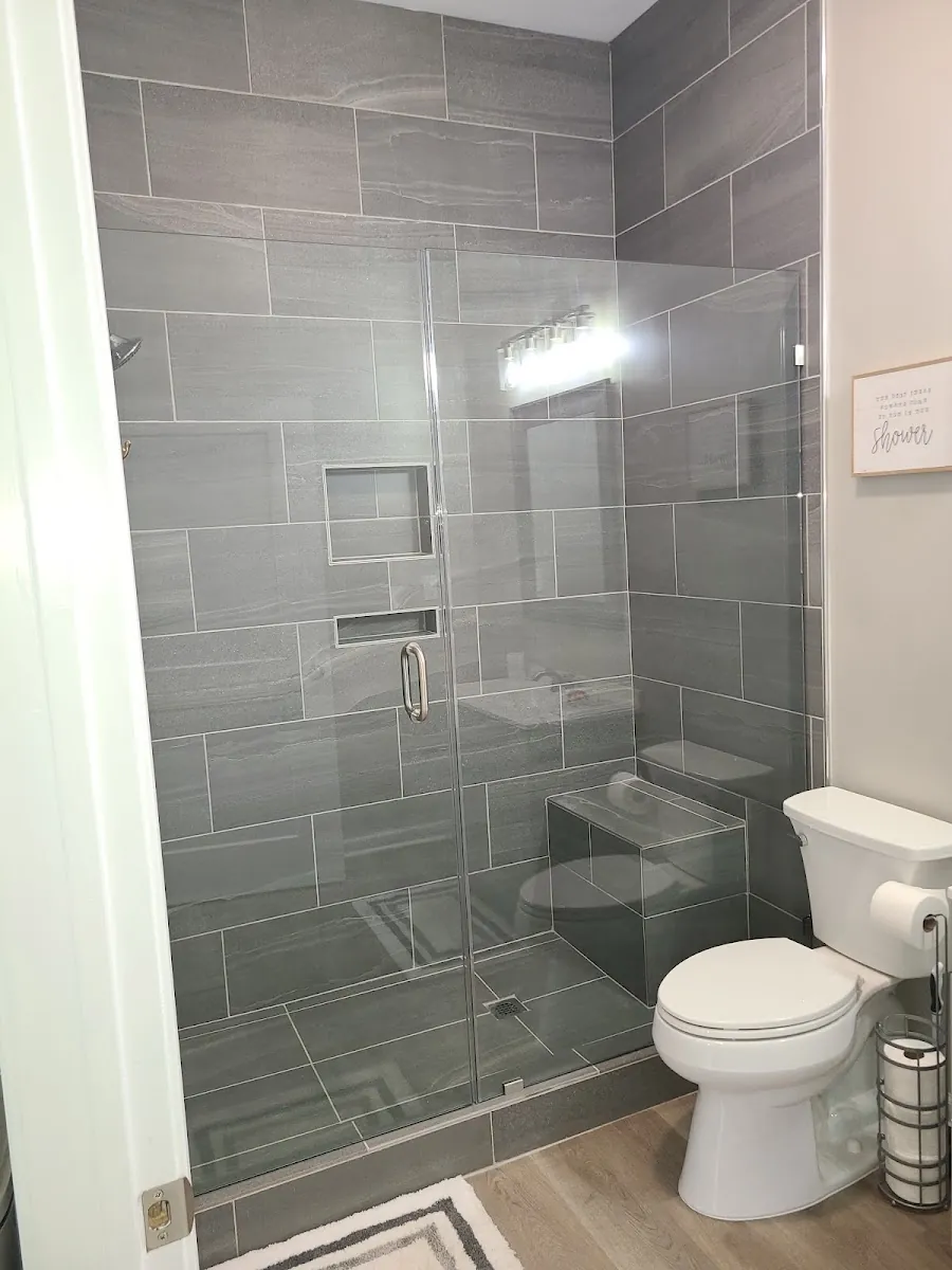 Tiled walk-in shower with recessed shampoo niche and glass surround