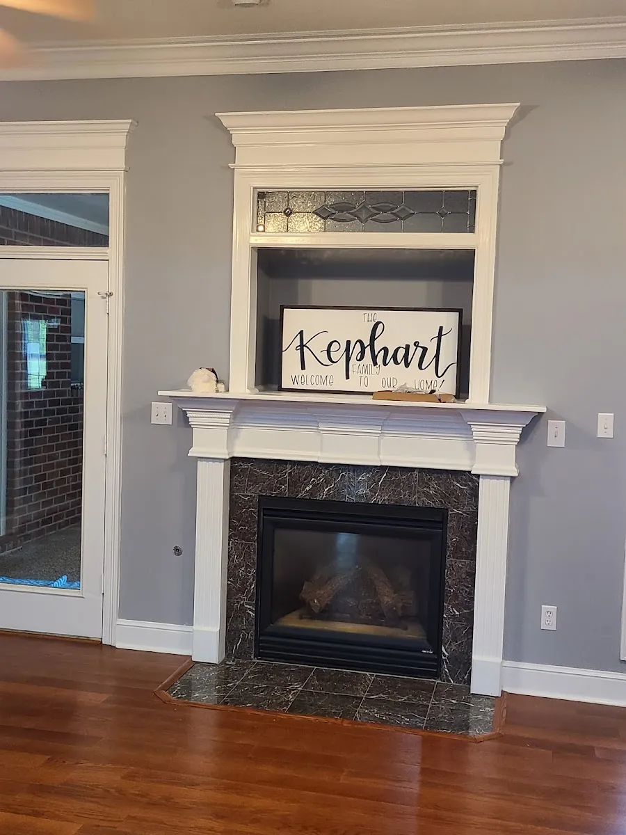 Painted fireplace mantel and surround with new trim in a remodeled living room
