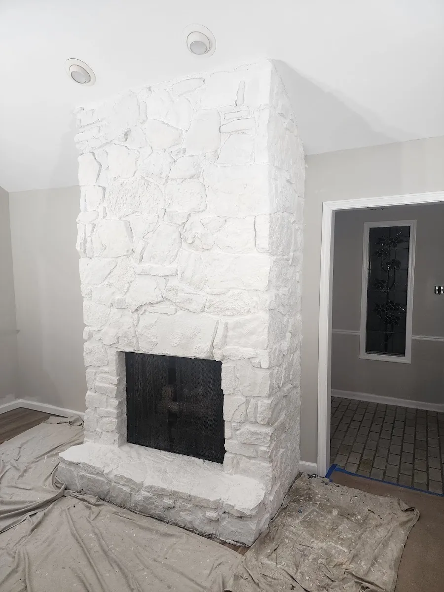 Floor-to-ceiling whitewashed stone fireplace built during a whole-home renovation