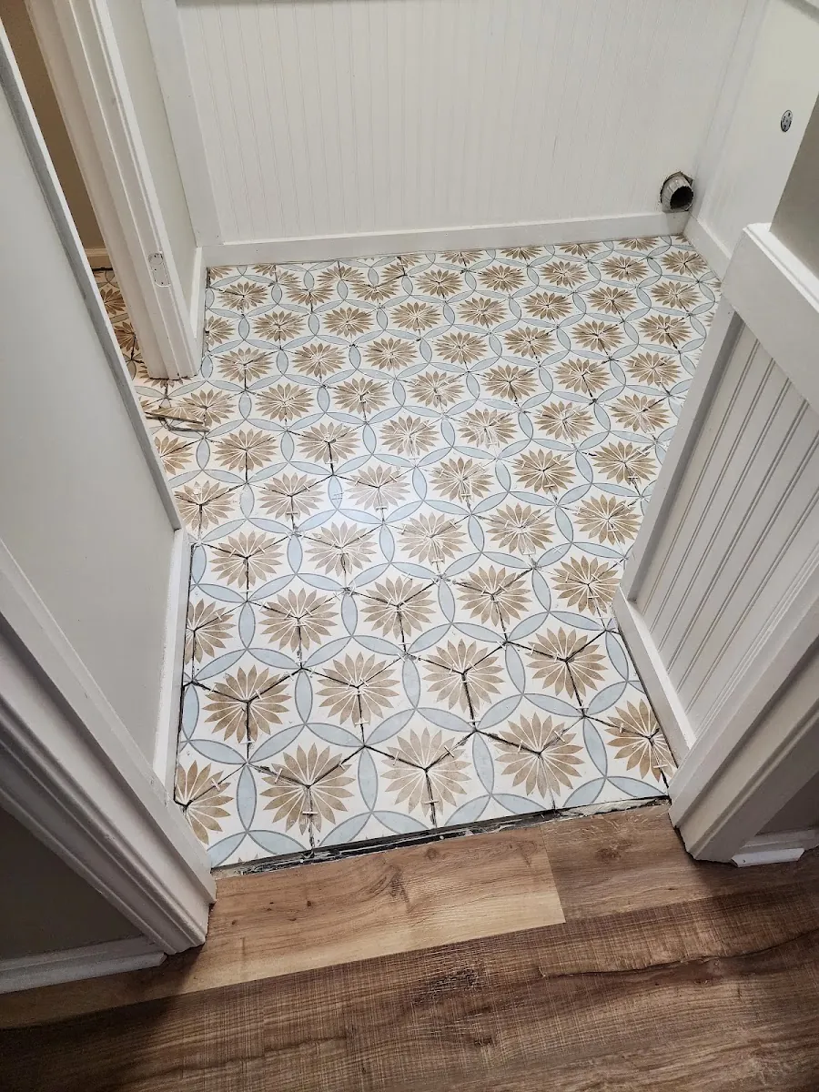 Patterned cement tile entry floor with board-and-batten wainscot and hardwood transition
