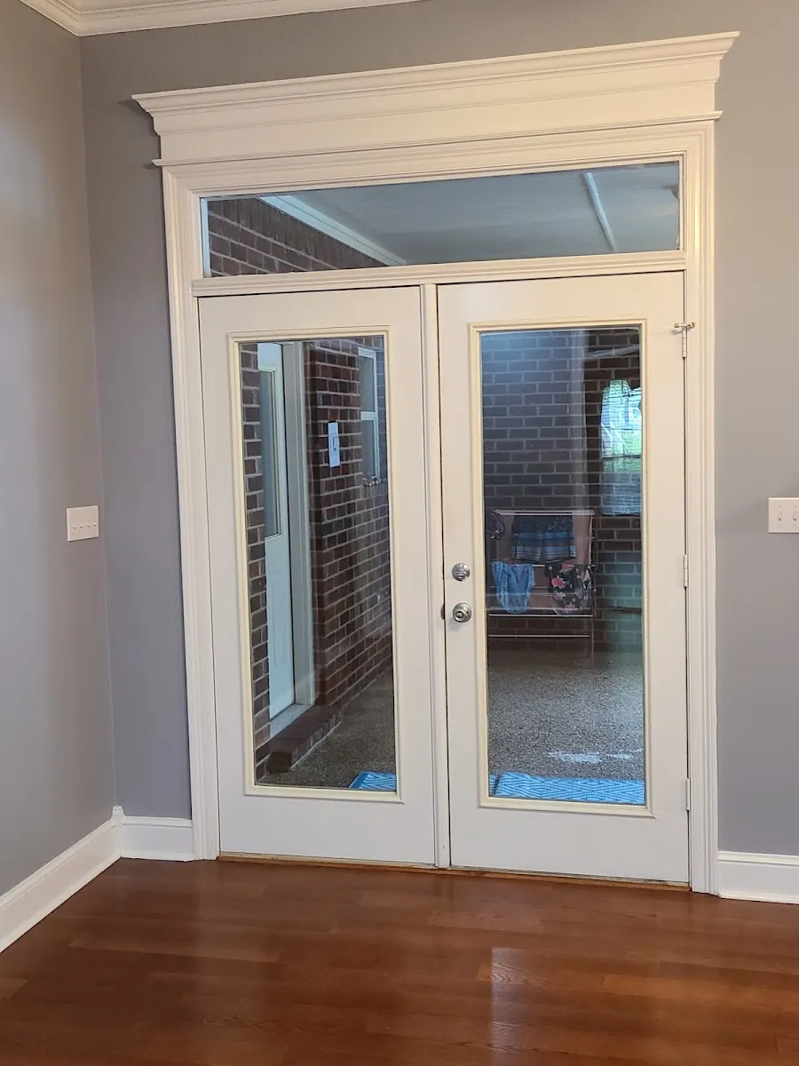 Interior French doors with transom window and refinished hardwood flooring