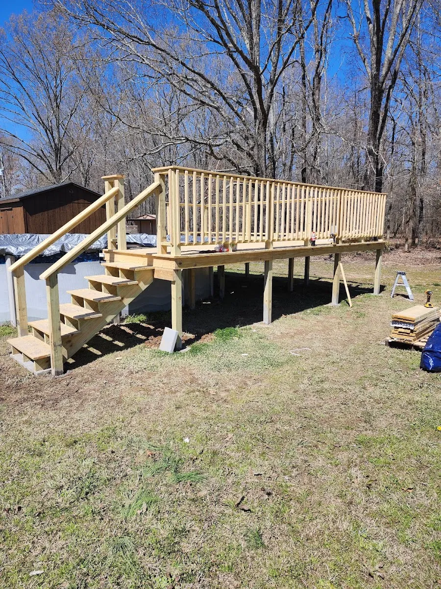 Custom deck build with stairs and railing on a sloped back yard