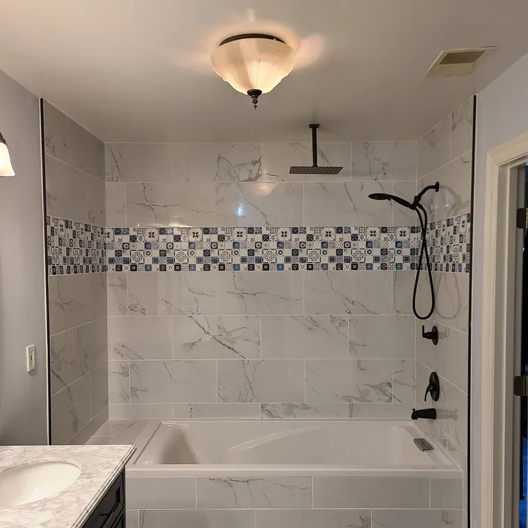 Marble tile bathroom remodel with a soaking tub, tiled surround and rainfall shower head