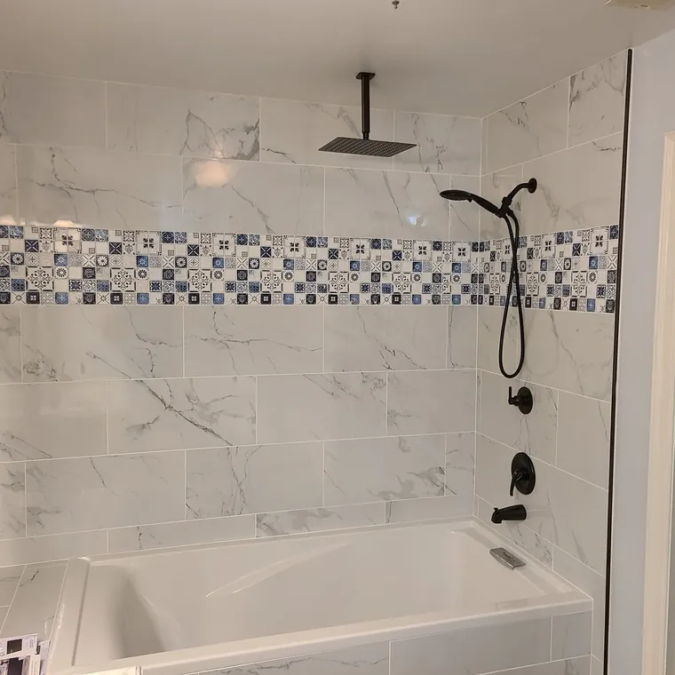 Tiled tub and shower combination with a decorative mosaic accent band