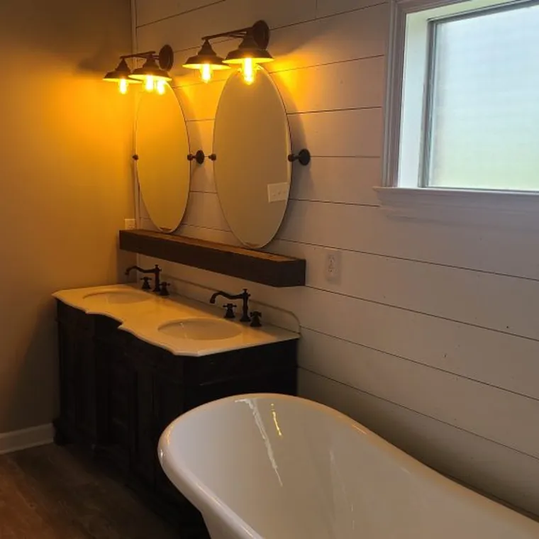 Bathroom with a freestanding soaking tub, shiplap wall and reclaimed wood vanity