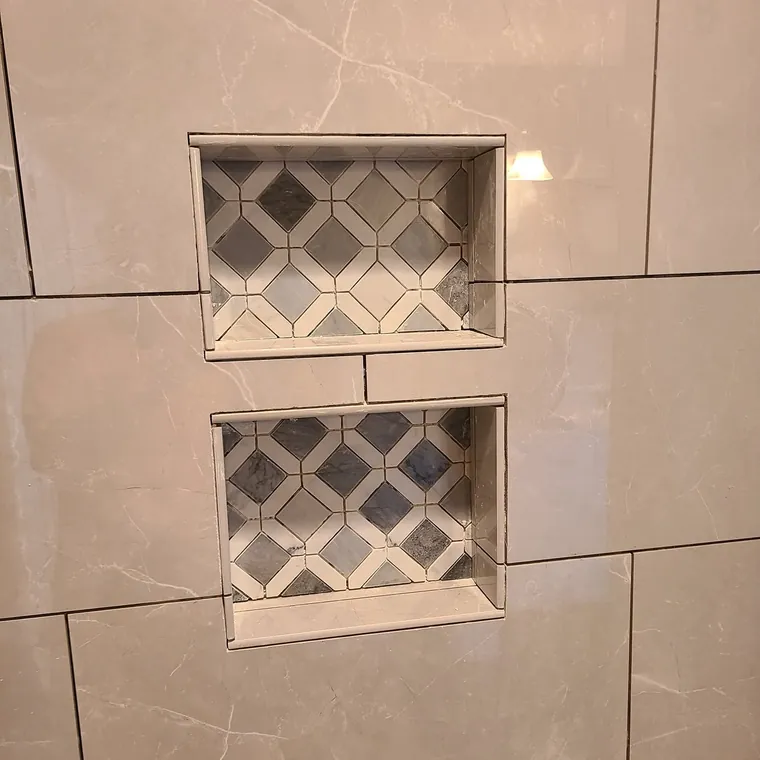 Close-up of two framed tile niches built into a shower wall