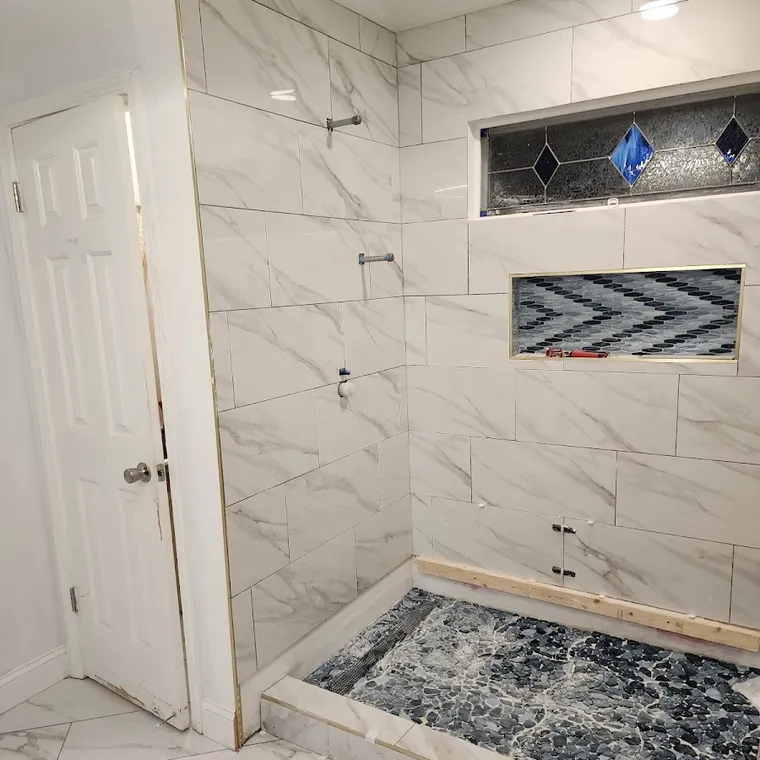 Marble tile walk-in shower with a built-in niche and mosaic shower floor