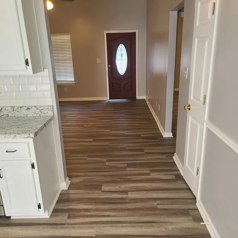New front door with glass insert seen from a hallway with new flooring