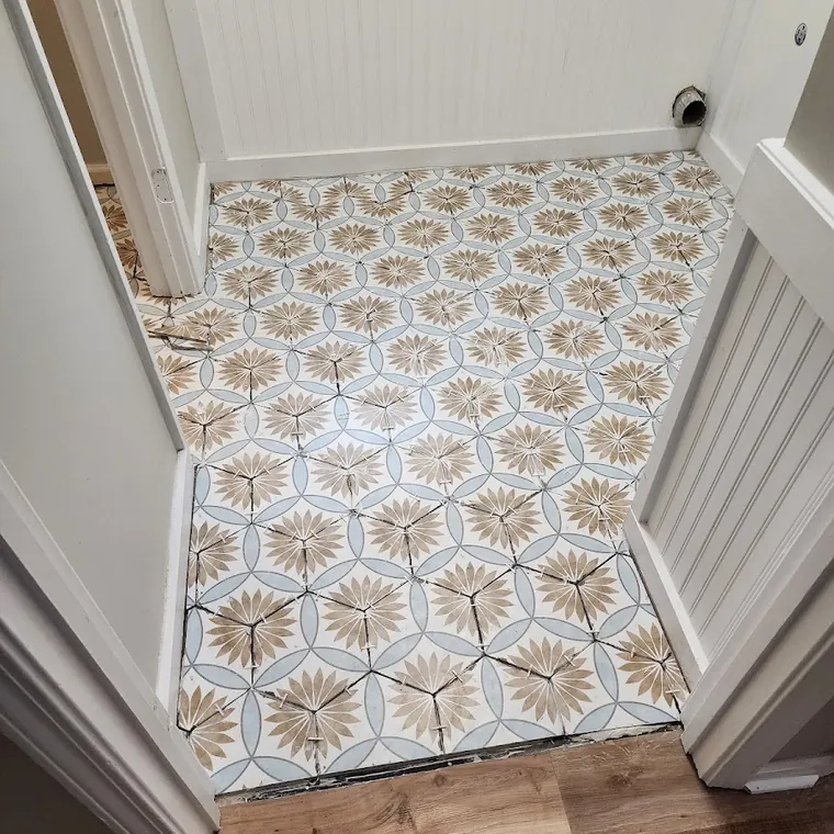 Patterned cement tile entry floor with board-and-batten wainscot and a hardwood transition