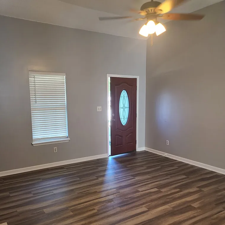 Wood-look plank flooring installed through a living room up to a new front door
