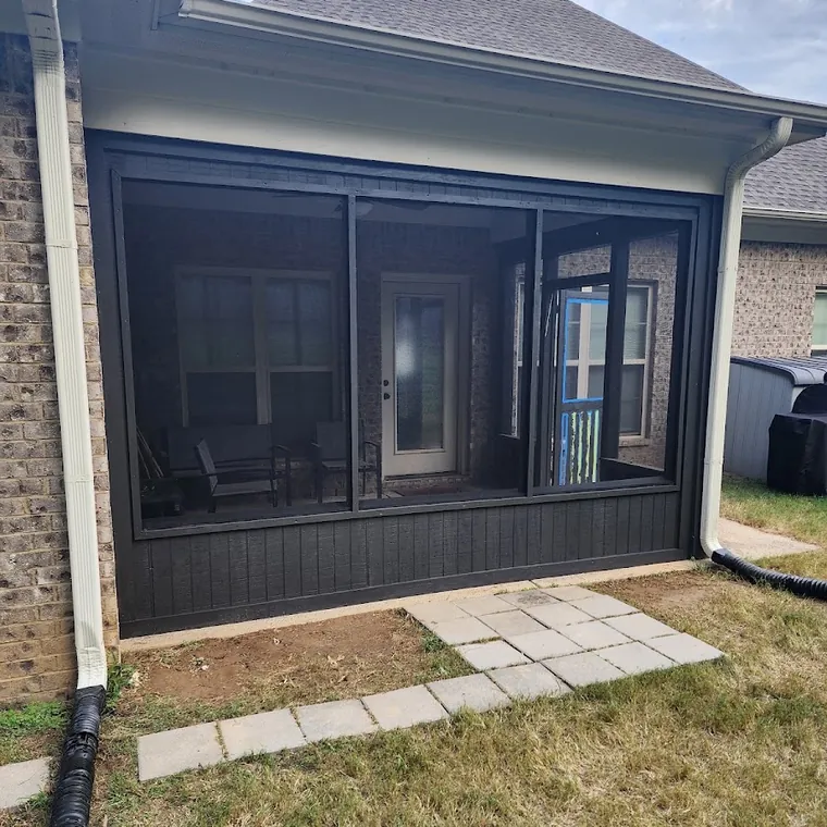 Rear porch addition under construction with new framing and a finished patio slab