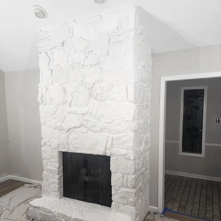 Floor-to-ceiling whitewashed stone fireplace built during a whole-home renovation