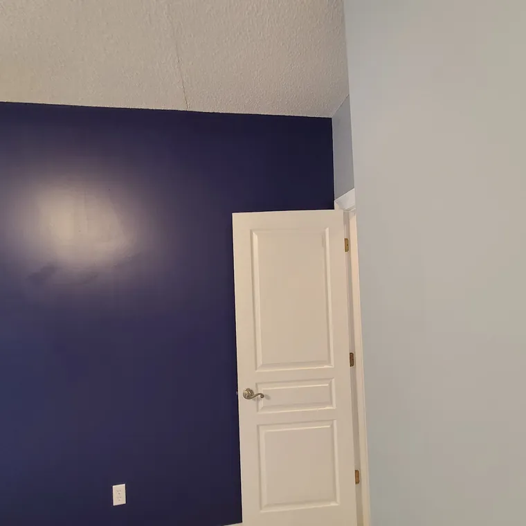 Freshly painted room with a deep purple accent wall and white trim